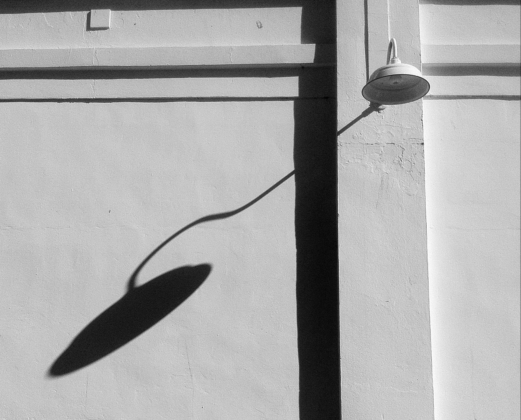Circular lamp shadow on white wall